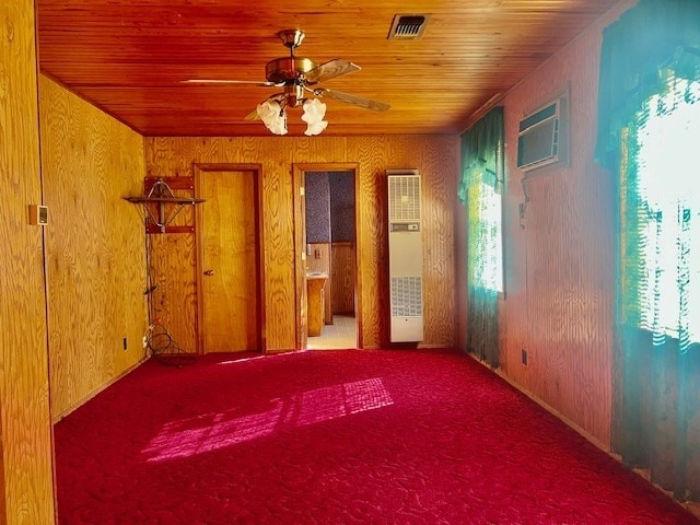 unfurnished room featuring ceiling fan, wooden ceiling, and wood walls