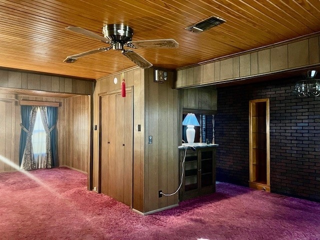 interior space featuring wooden walls and dark colored carpet