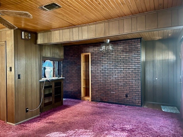 interior space with carpet flooring, brick wall, and wooden walls