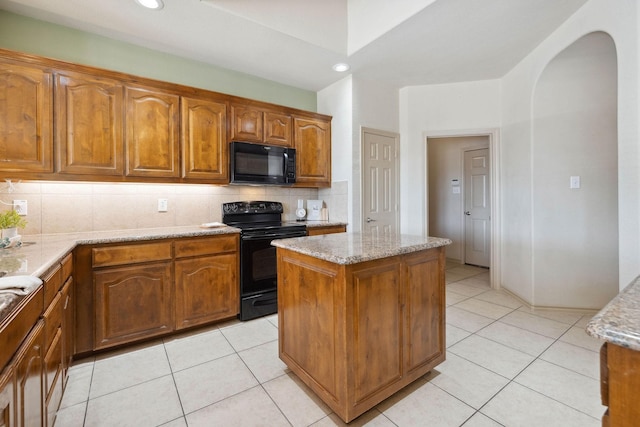 kitchen featuring light stone counters, backsplash, black appliances, and light tile patterned flooring