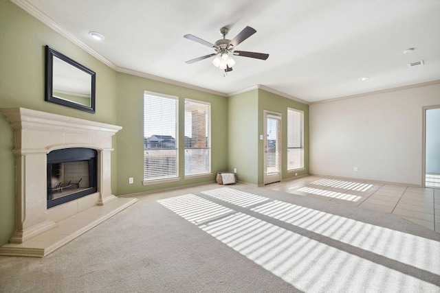 unfurnished living room with crown molding, ceiling fan, light carpet, and a tile fireplace