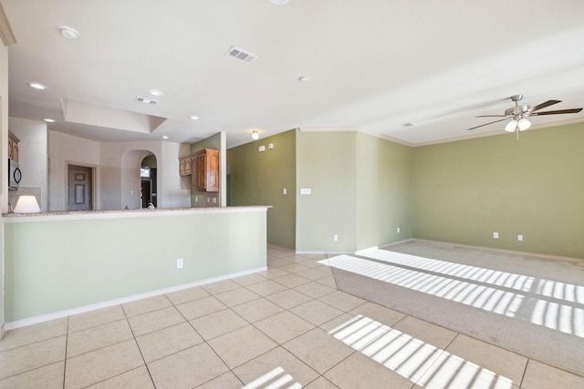 tiled spare room with ornamental molding and ceiling fan