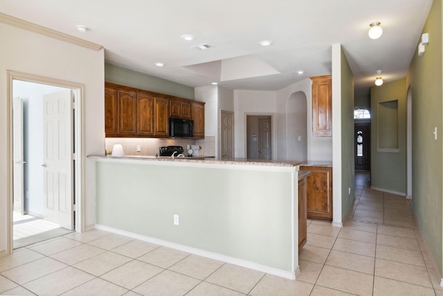 kitchen with light tile patterned floors, crown molding, tasteful backsplash, light stone countertops, and kitchen peninsula