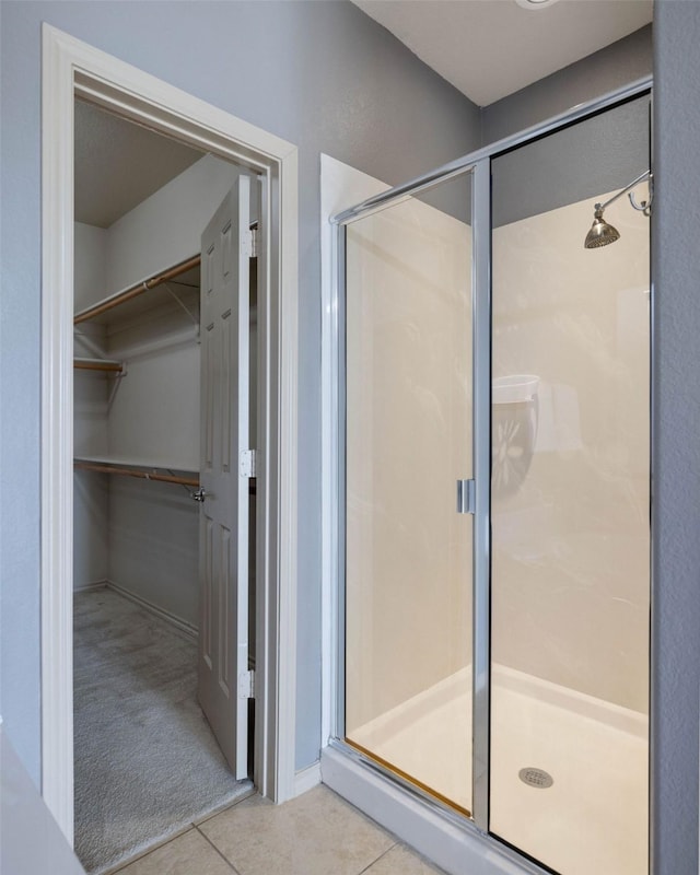 bathroom featuring tile patterned flooring and a shower with shower door