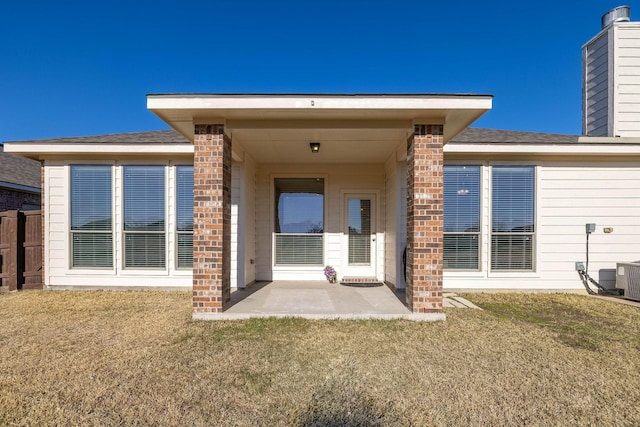 back of house featuring a patio area and a lawn