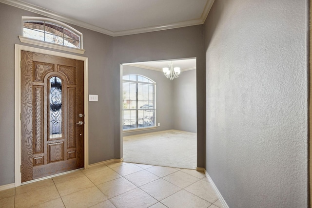 foyer entrance with a notable chandelier, ornamental molding, and light tile patterned floors