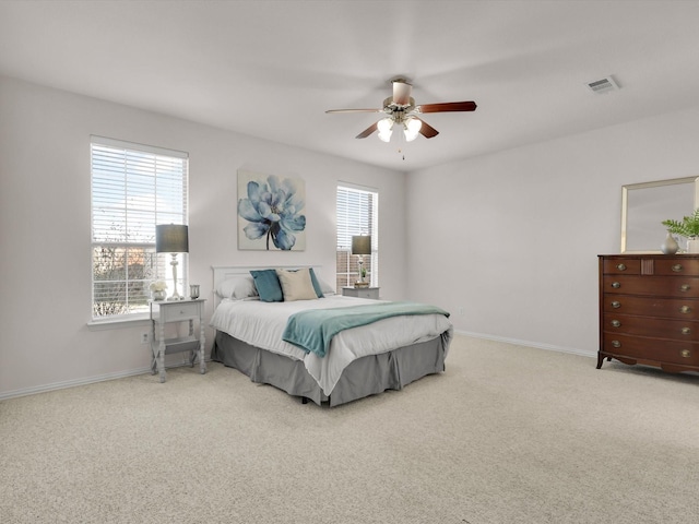 carpeted bedroom featuring ceiling fan and multiple windows