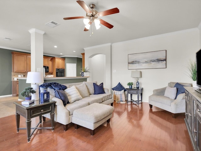 living room featuring crown molding, dark wood-type flooring, and ceiling fan