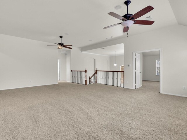 carpeted spare room featuring plenty of natural light, ceiling fan, and vaulted ceiling