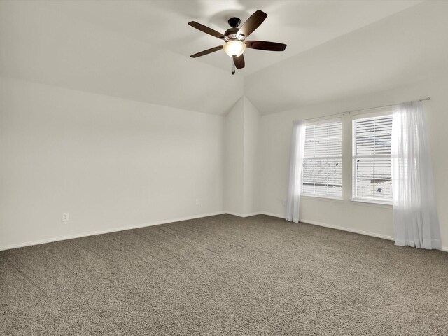 unfurnished room with ceiling fan, light colored carpet, and vaulted ceiling