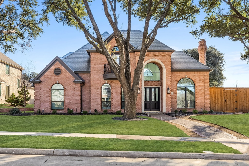 view of front of home with french doors and a front lawn