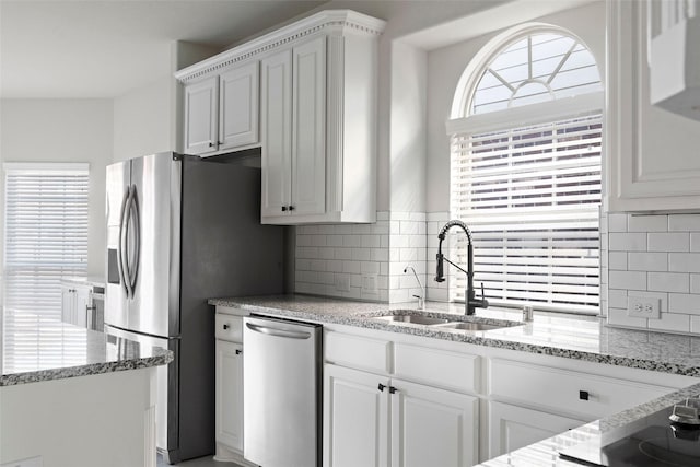 kitchen with sink, tasteful backsplash, plenty of natural light, stainless steel appliances, and white cabinets