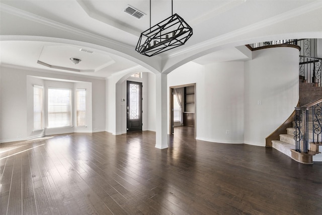 interior space with dark hardwood / wood-style flooring, crown molding, and a raised ceiling