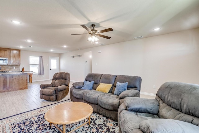 living room featuring ceiling fan and light wood-type flooring