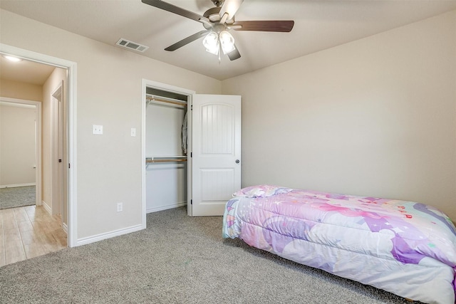 carpeted bedroom with ceiling fan and a closet