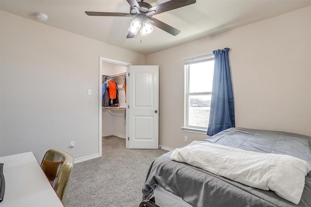 bedroom featuring light carpet, a spacious closet, a closet, and ceiling fan