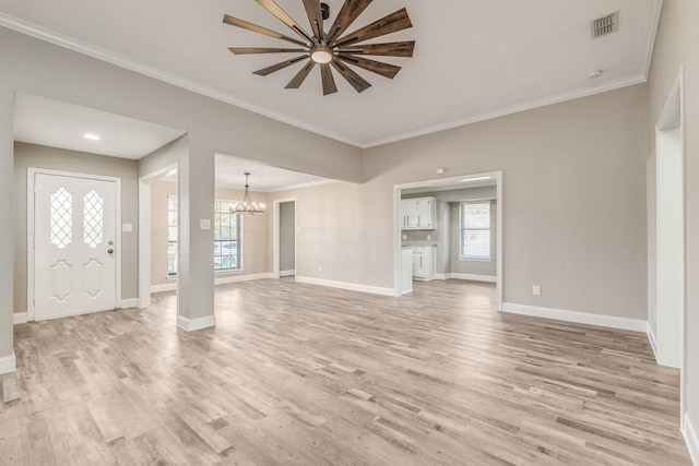 interior space with ornamental molding, ceiling fan with notable chandelier, and light hardwood / wood-style flooring