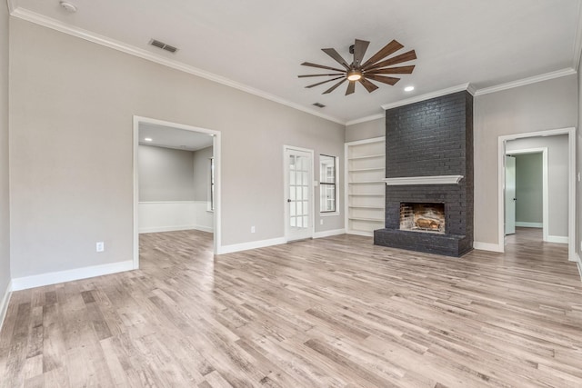 unfurnished living room featuring a brick fireplace, light wood-type flooring, ornamental molding, built in features, and ceiling fan