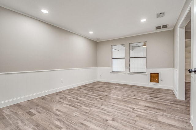 empty room featuring ornamental molding and light hardwood / wood-style floors