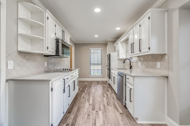 kitchen with sink, ornamental molding, stainless steel appliances, and white cabinets