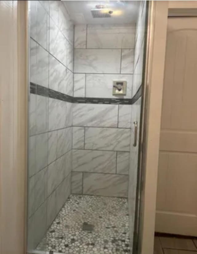 bathroom featuring tile patterned flooring and a shower with door