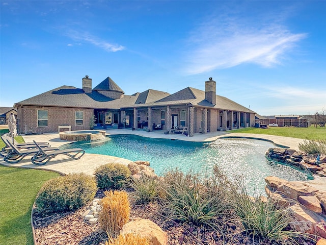 view of pool with an in ground hot tub and a patio area