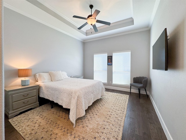 bedroom with dark hardwood / wood-style flooring, a tray ceiling, ornamental molding, and ceiling fan