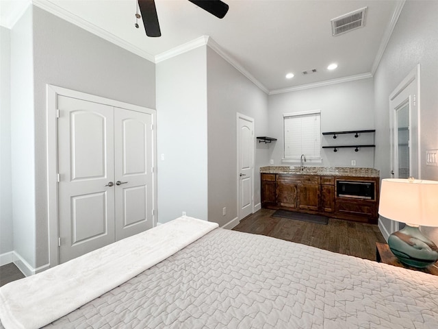 bedroom featuring ornamental molding, dark hardwood / wood-style floors, sink, and ceiling fan