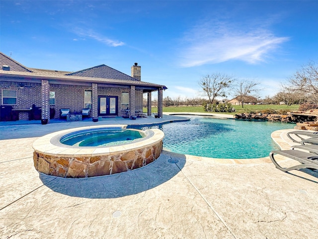 view of pool with an in ground hot tub, a patio area, and french doors