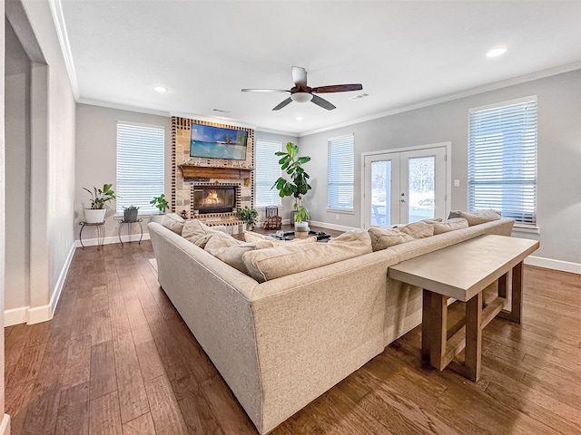 living room featuring crown molding, dark hardwood / wood-style floors, a fireplace, and french doors