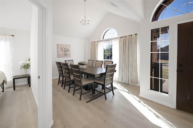 dining room featuring an inviting chandelier, vaulted ceiling, and light wood-type flooring