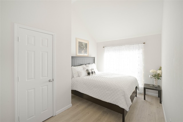 bedroom featuring lofted ceiling and light hardwood / wood-style flooring