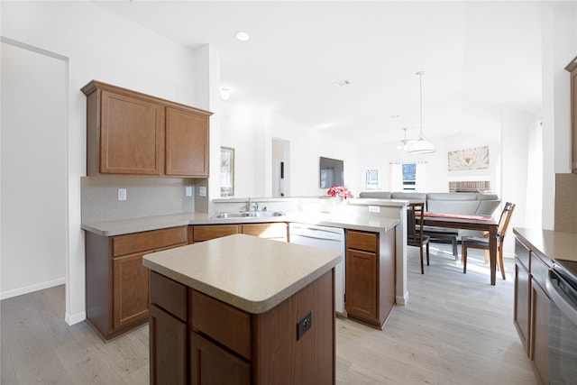 kitchen with sink, light hardwood / wood-style floors, dishwasher, and a kitchen island