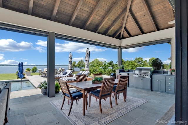 view of patio with a water view, a grill, exterior kitchen, and a gazebo