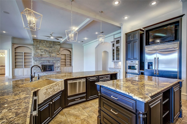 kitchen featuring built in shelves, oven, hanging light fixtures, and a kitchen island