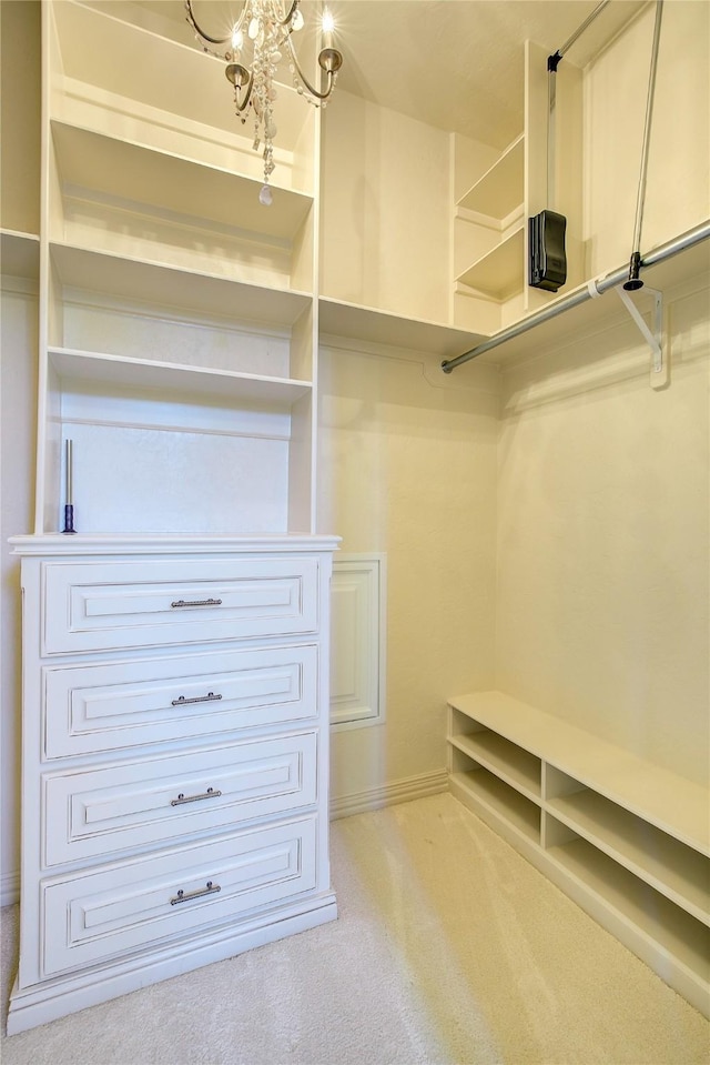 walk in closet featuring carpet floors and a chandelier