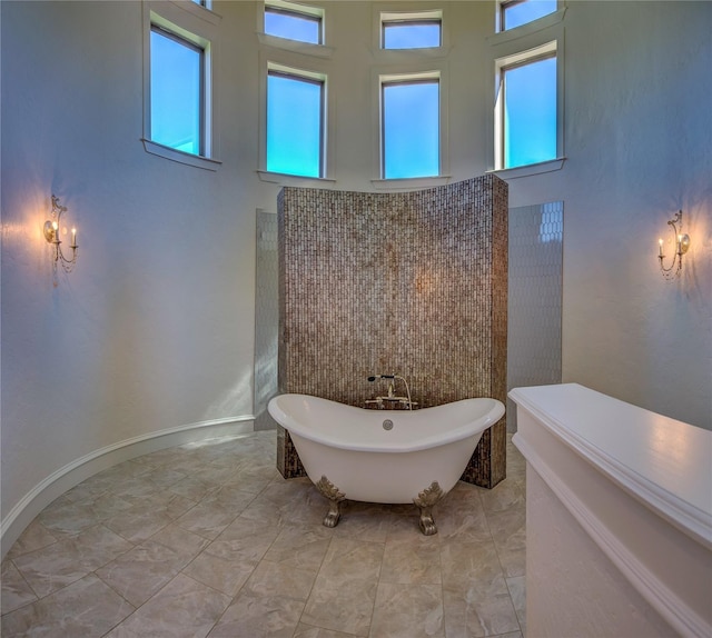 bathroom featuring a tub to relax in and a high ceiling