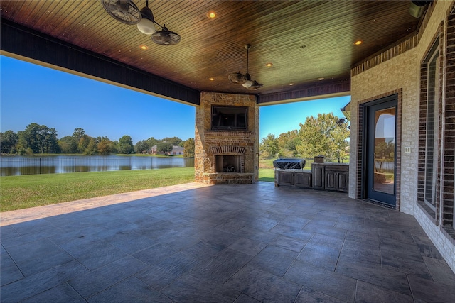 view of patio / terrace with ceiling fan, a grill, and an outdoor stone fireplace