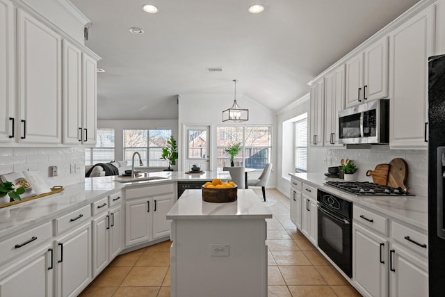 kitchen with lofted ceiling, white cabinetry, tasteful backsplash, kitchen peninsula, and black appliances