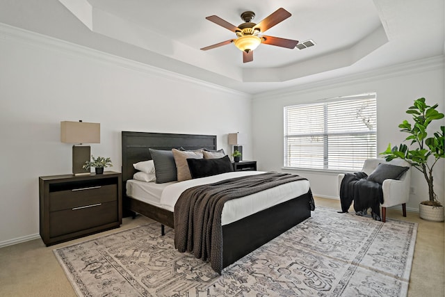 carpeted bedroom featuring crown molding, ceiling fan, and a raised ceiling