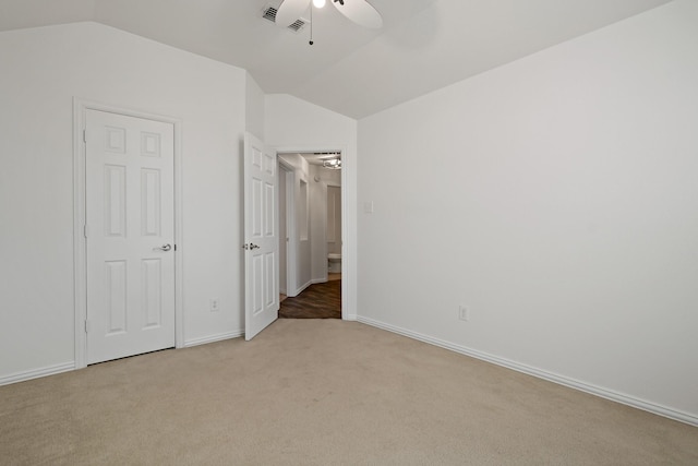 unfurnished bedroom featuring ceiling fan, lofted ceiling, and light colored carpet