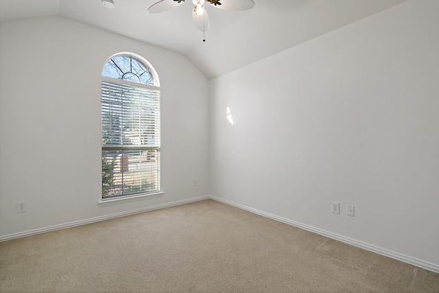 carpeted empty room with ceiling fan, vaulted ceiling, and a healthy amount of sunlight