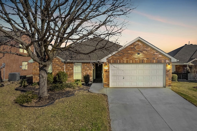 view of front of house with a garage, central AC, and a lawn