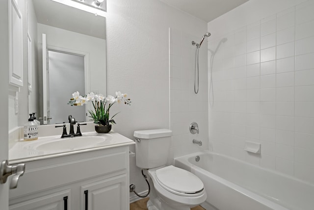 full bathroom with tiled shower / bath, vanity, and toilet