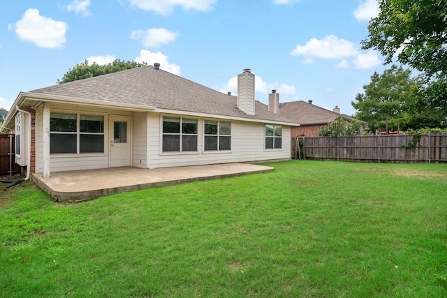 rear view of house with a patio and a yard