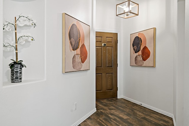 entryway featuring a notable chandelier and dark wood-type flooring