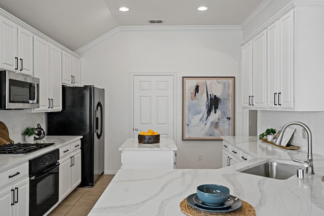 kitchen featuring sink, tasteful backsplash, light stone counters, black appliances, and white cabinets