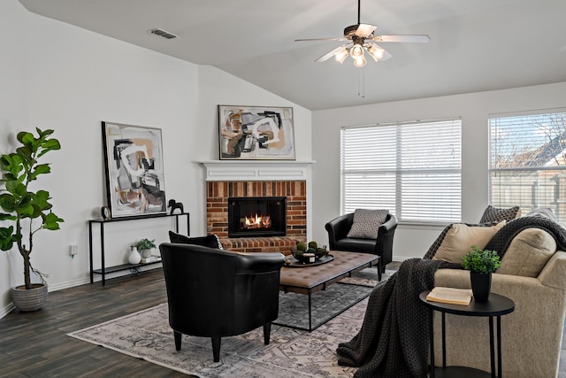 living room featuring a brick fireplace, vaulted ceiling, dark hardwood / wood-style floors, and ceiling fan