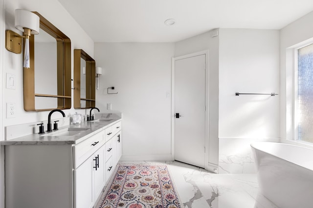 bathroom featuring a freestanding tub, a sink, marble finish floor, and double vanity