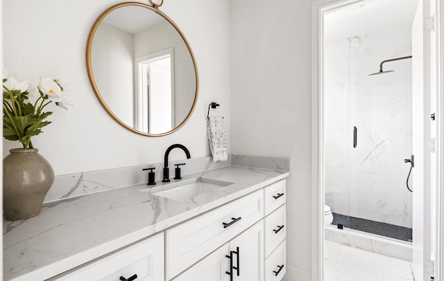 full bath with toilet, a marble finish shower, and vanity